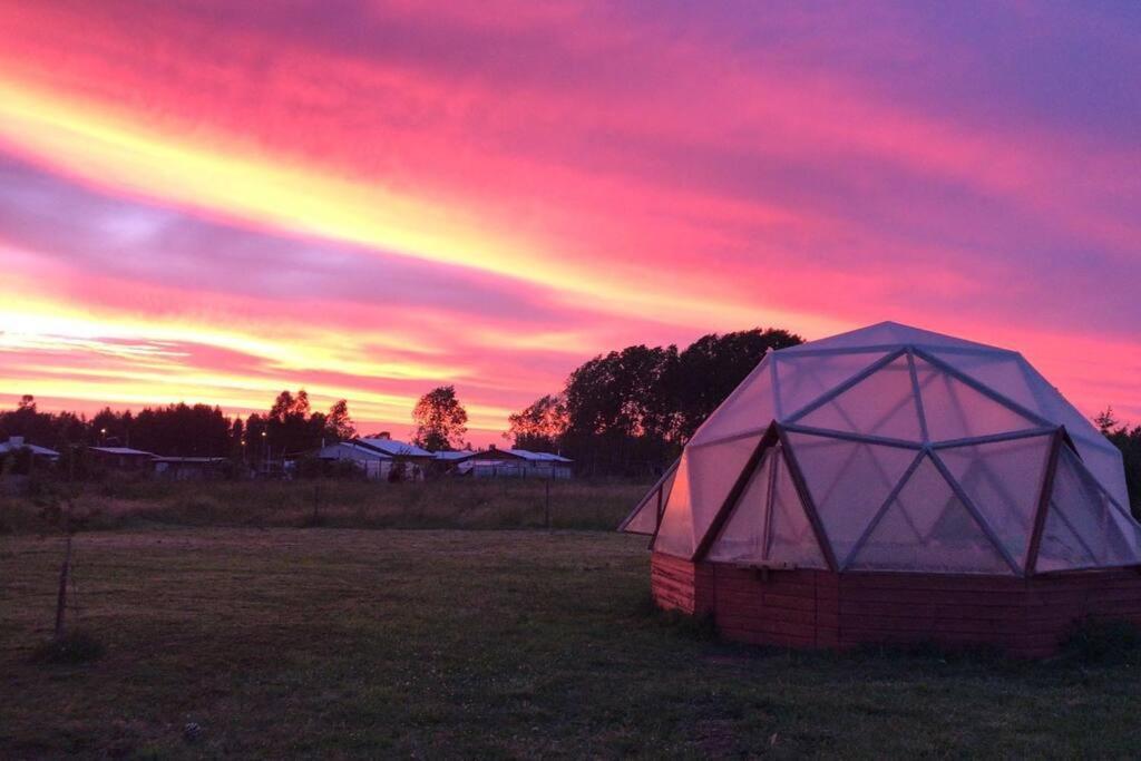 ein Zelt auf einem Feld mit Regenbogen am Himmel in der Unterkunft Casa El Arrebol, sector Saltos del Laja in Cabrero