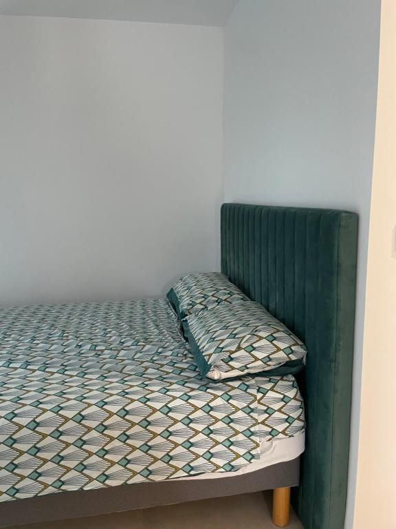 - un lit vert dans un coin de chambre dans l'établissement Appartement lumineux T2 avec terrasse et jardin, à Calvi