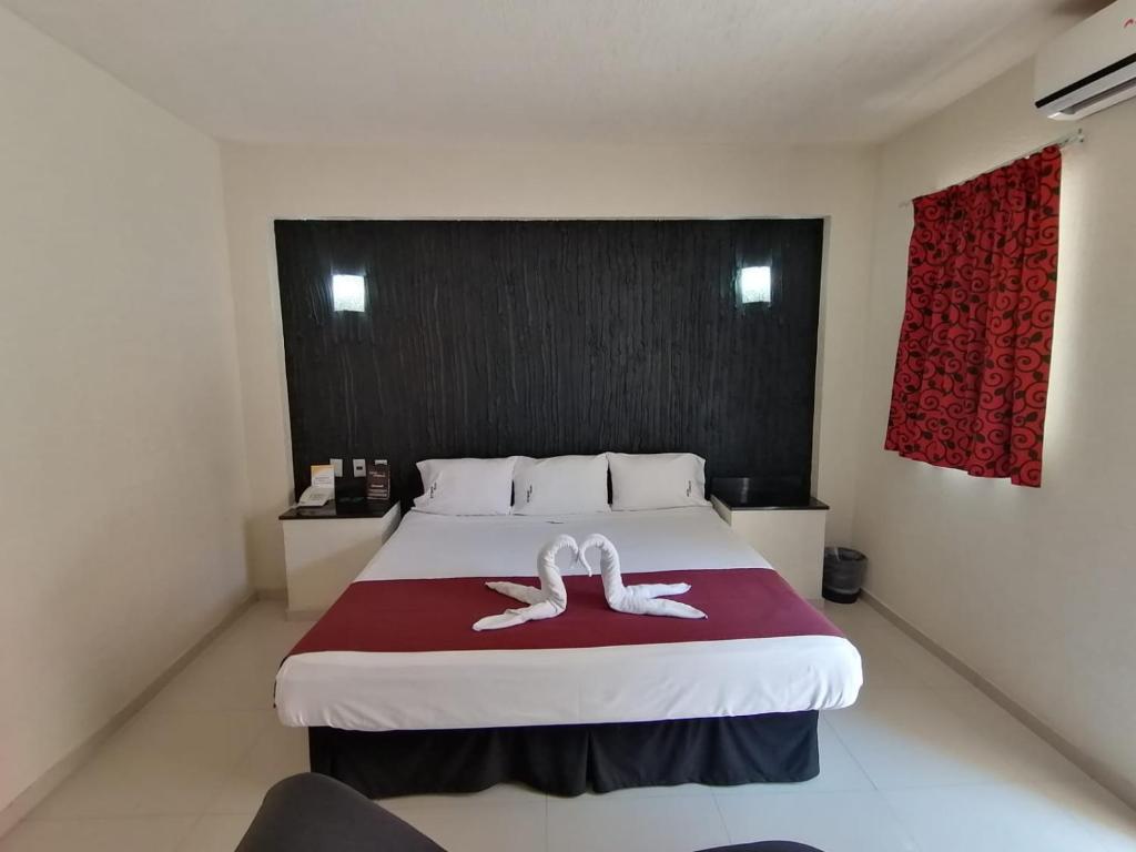 a bedroom with a bed with two white towels on it at HOTEL MORELOS in Guadalajara