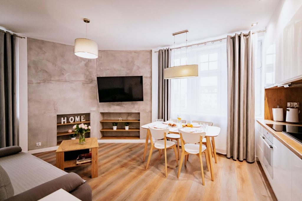 ブィドゴシュチュにあるOttimo Apartamenty Florianaのキッチン、リビングルーム(テーブル、椅子付)