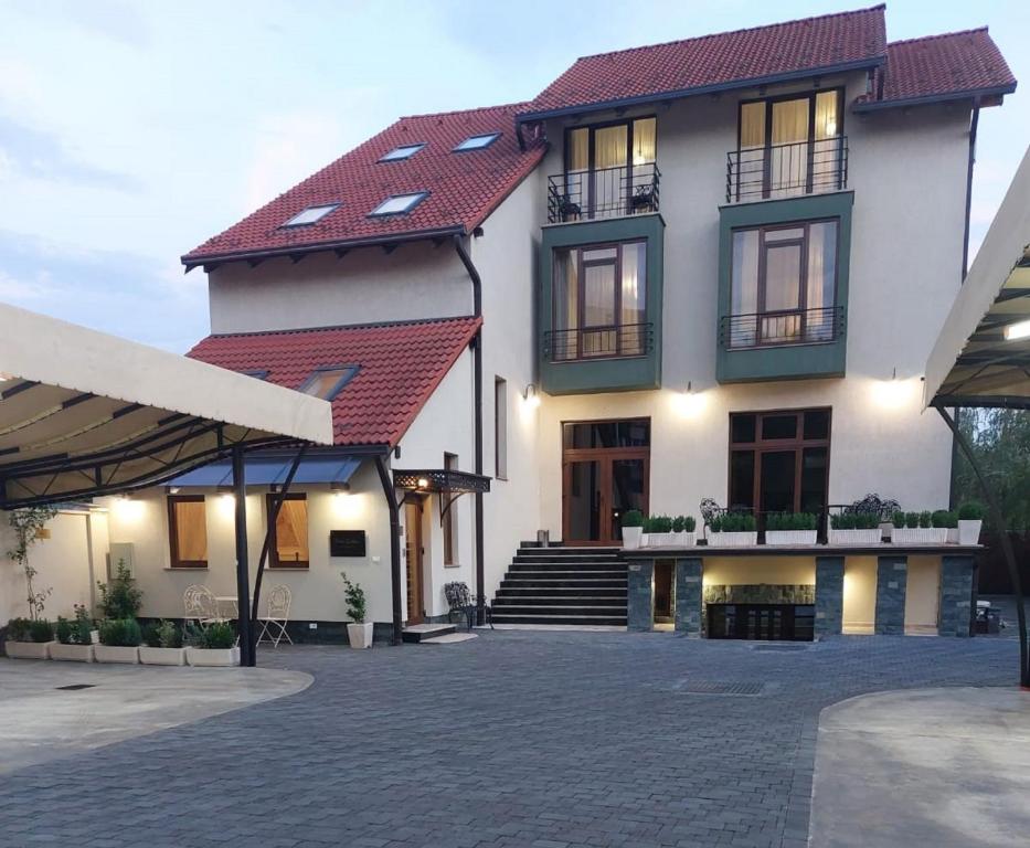 a large white building with a red roof at Perla Sudului - Residence in Timişoara