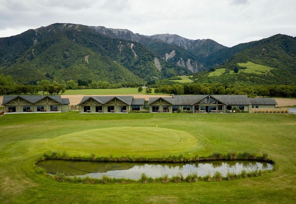 Blick auf einen Golfplatz mit Bergen im Hintergrund in der Unterkunft Koura Bay Golf Resort in Kaikoura
