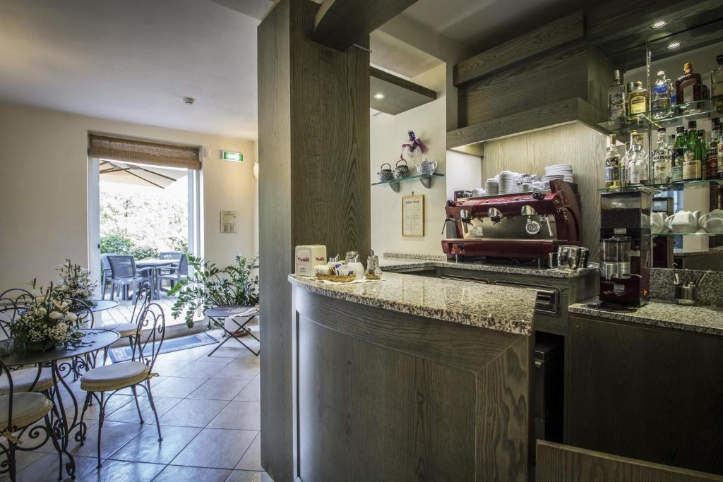 a kitchen with a counter and a table with chairs at Hotel Riviera Blu in Tirrenia