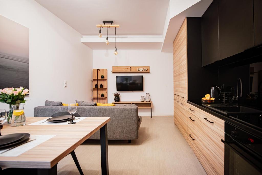 Il comprend une cuisine et un salon avec une table et un canapé. dans l'établissement Ottimo Apartamenty Dolina, à Bydgoszcz
