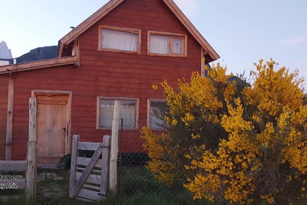 una casa roja con una puerta delante de ella en La Joaquina, Casa de montaña. en El Chalten