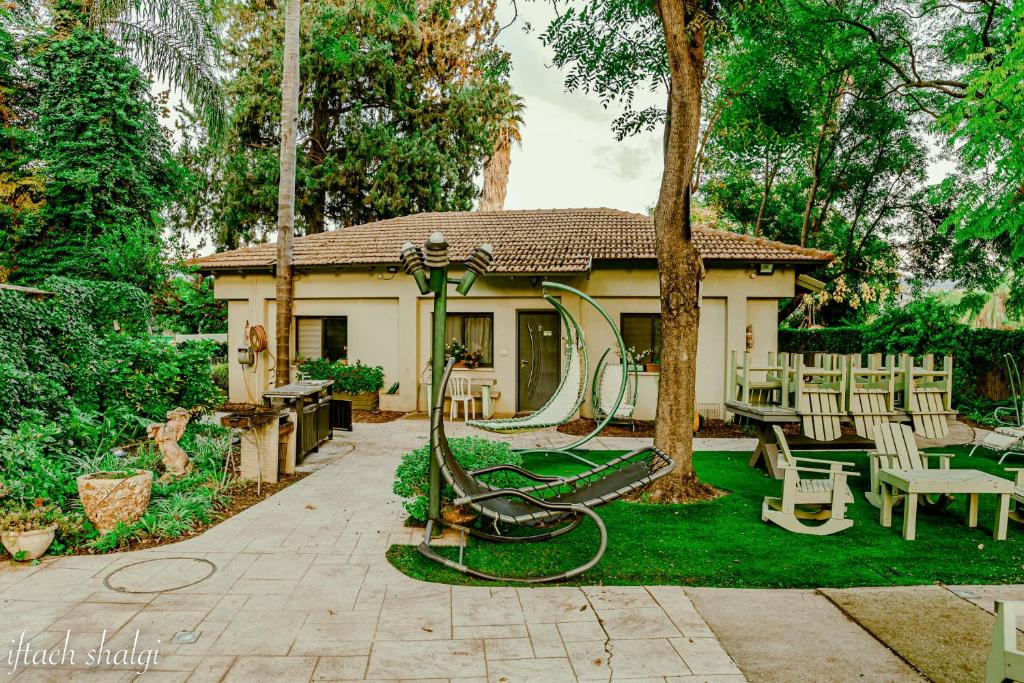 a house with a playground in the yard at Nuriel Fruit & Guest House in Sheʼar Yashuv