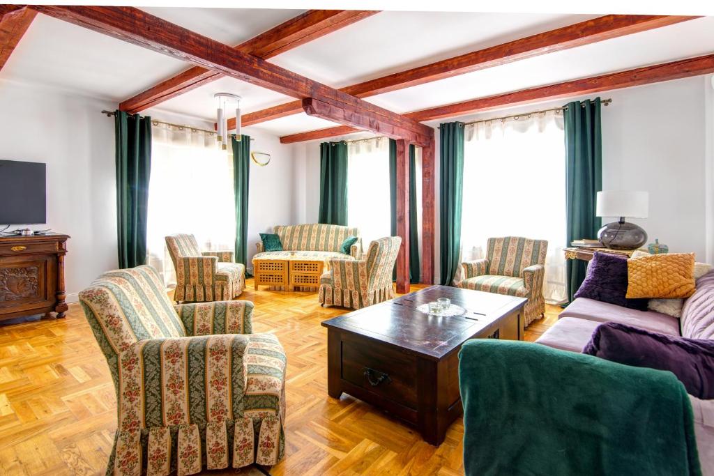 uma sala de estar com sofás e cadeiras e uma mesa em Rentimi - Willa Bella Kościelna 28 em Muszyna