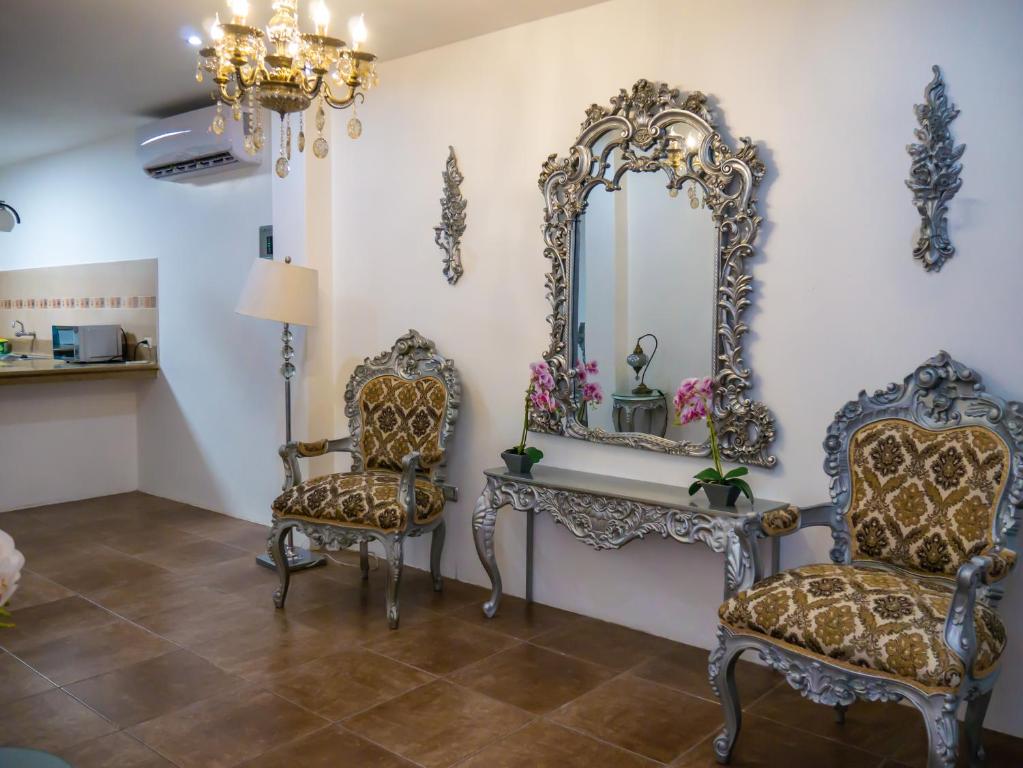 a room with two chairs and a mirror at The Royalty Inn ApartmentHotel #1 in Guayaquil