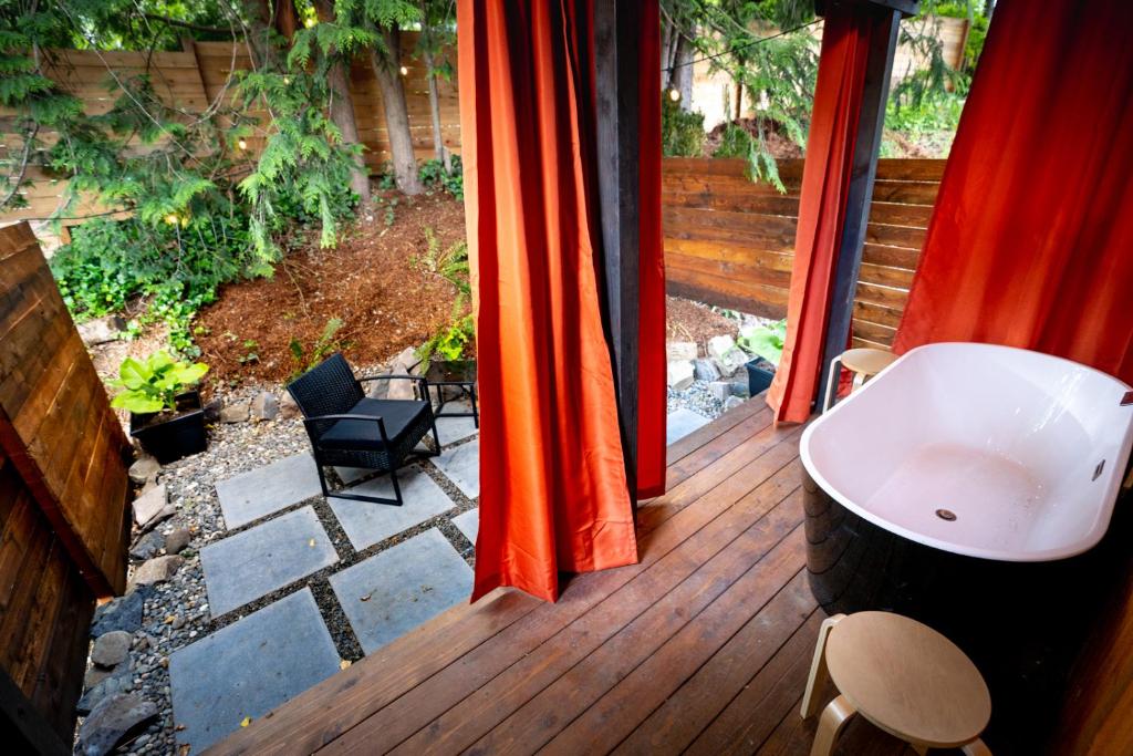 a deck with a bath tub on a wooden porch at Artbliss Hotel in Stevenson