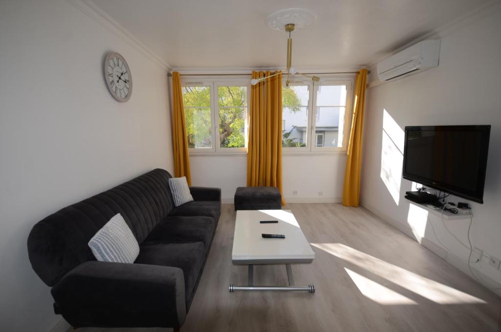 salon z kanapą i stołem w obiekcie Superbe appartement Montpellier 8 personnes 2 chambres 2 salles de bain Wifi Netflix et parking gratuit w Montpellier