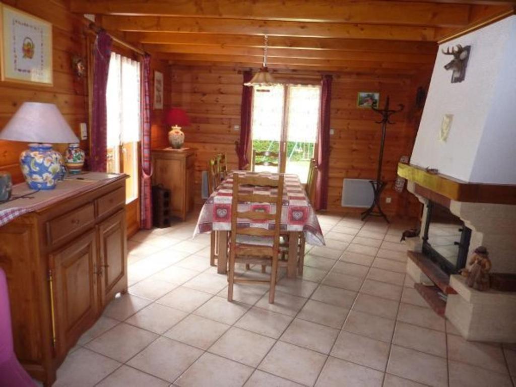 a dining room with a table in a log cabin at Gîte Le Menil, 5 pièces, 5 personnes - FR-1-589-107 in Le Ménil