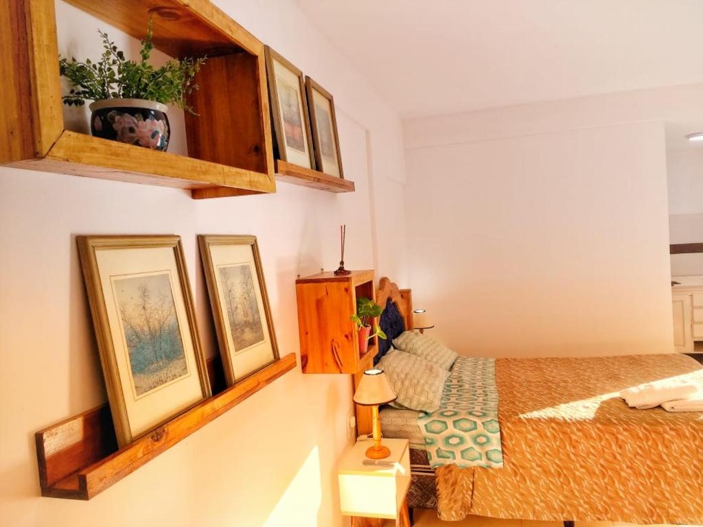 een slaapkamer met een bed en wat foto's aan de muur bij departamentos sebas llanoo san rafael PLENO CENTRO in San Rafael