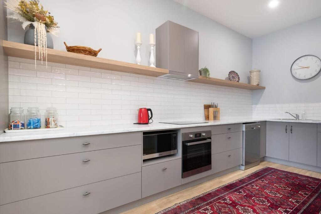 a kitchen with white appliances and a red rug at The Ranch In The Heart Of Launceston w/ Free Wifi in Launceston