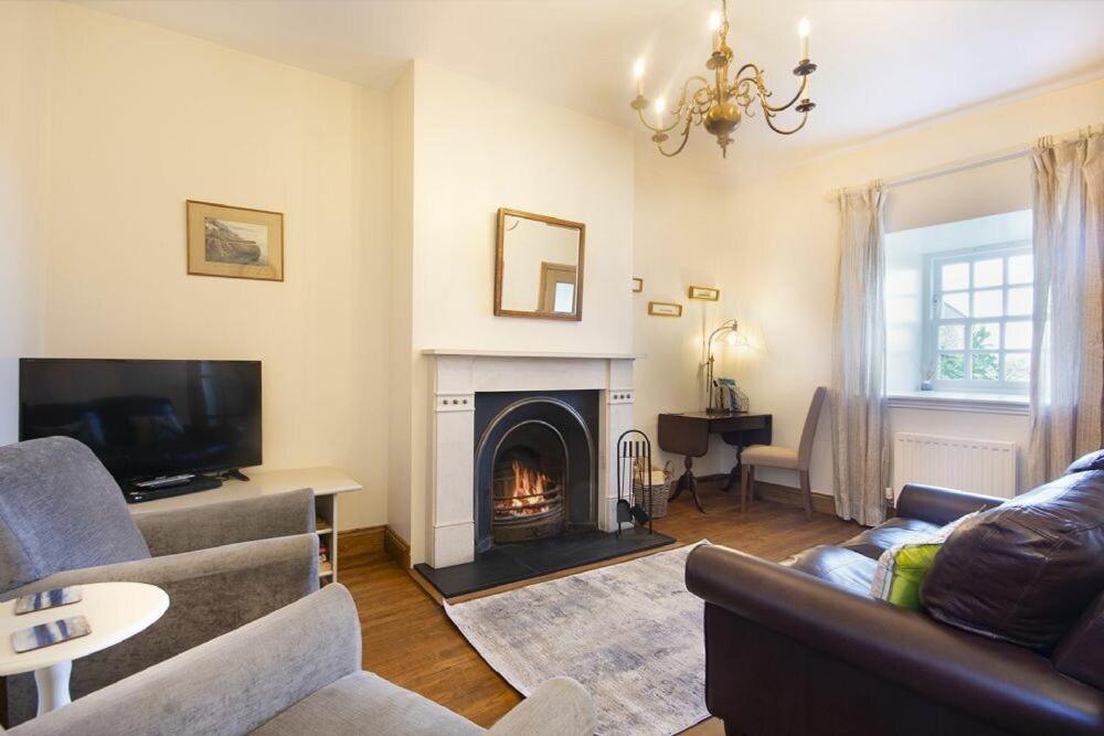 a living room with a couch and a fireplace at No9 Budle Sands in Bamburgh