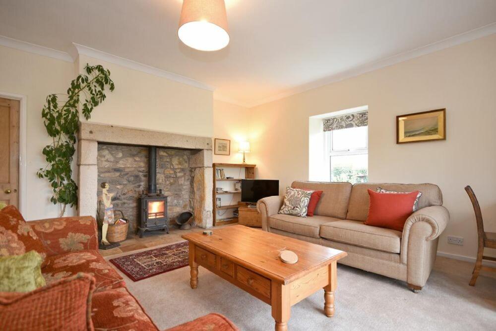 a living room with a couch and a fireplace at Dunrovin in Beadnell