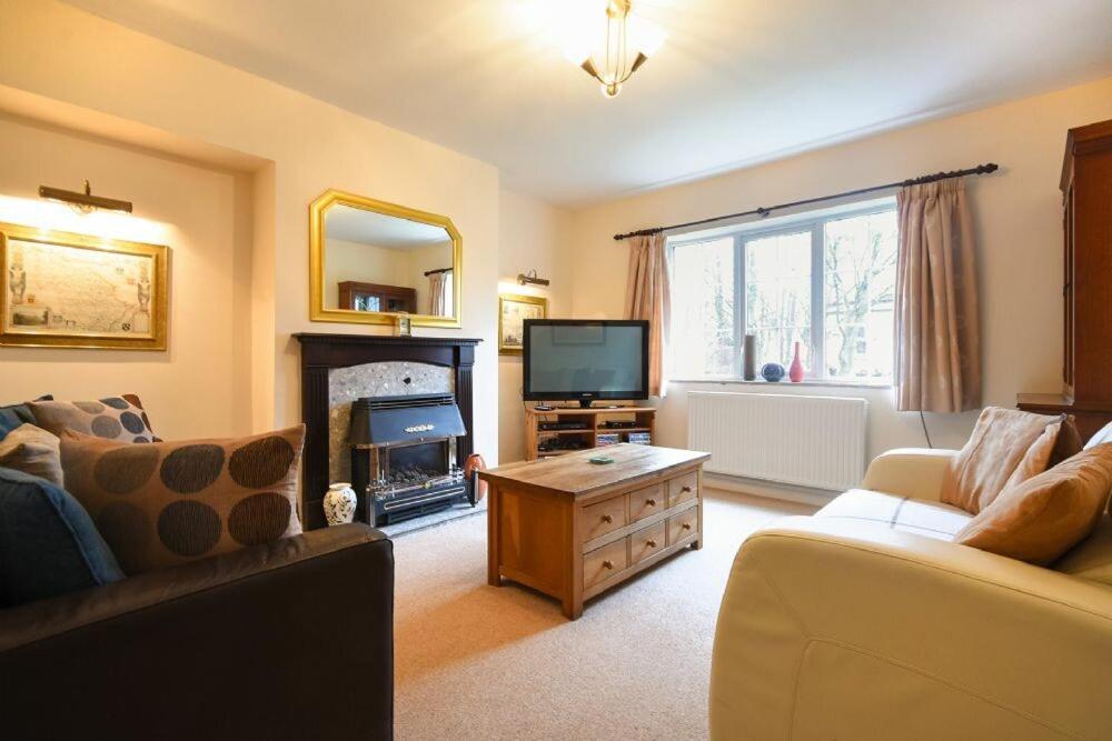 a living room with a couch and a tv at Castle View Warkworth in Warkworth