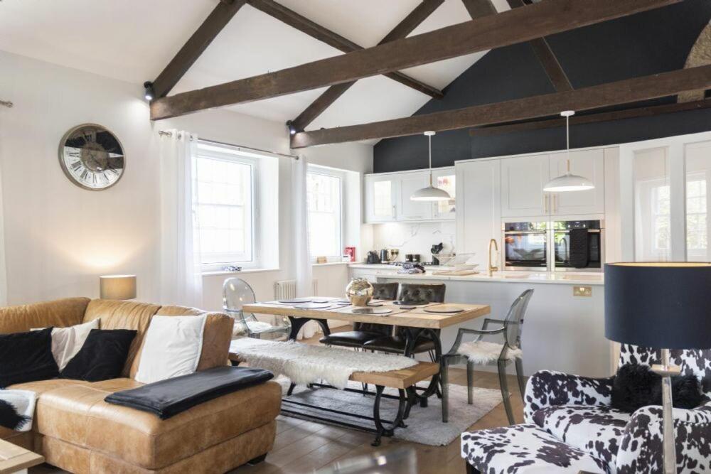 a living room with a couch and a table and a kitchen at Treetops, Alnwick in Alnwick