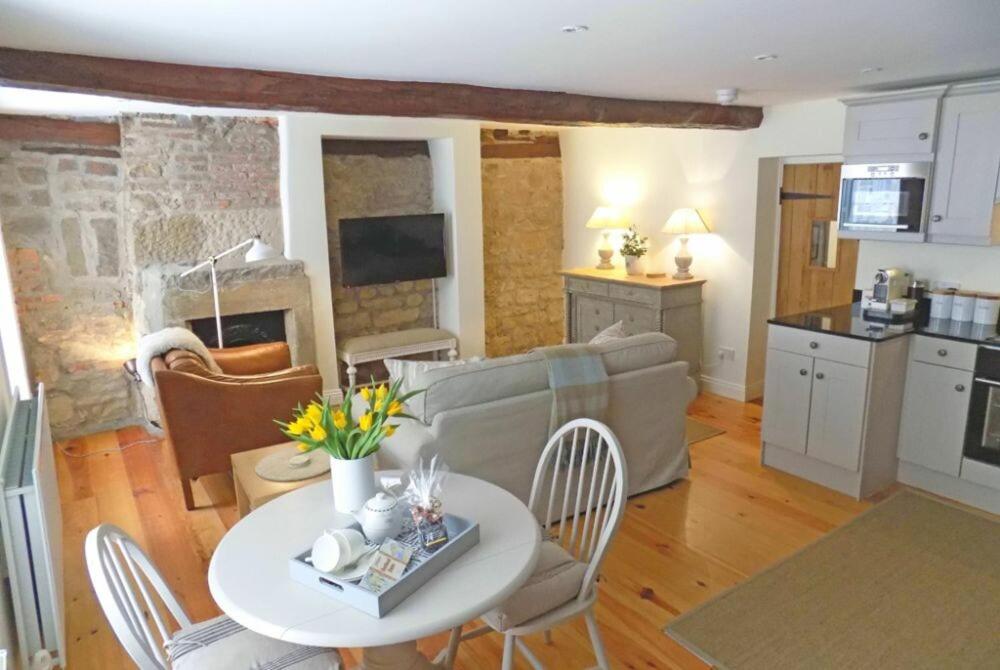 a kitchen and a living room with a table and chairs at Dorothy Forster Court in Alnwick