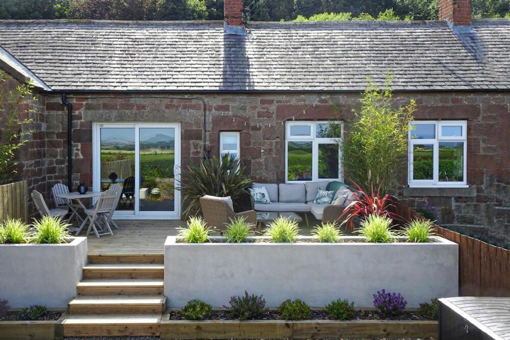 a garden with a patio and a house at Bellshill Cottage in Belford