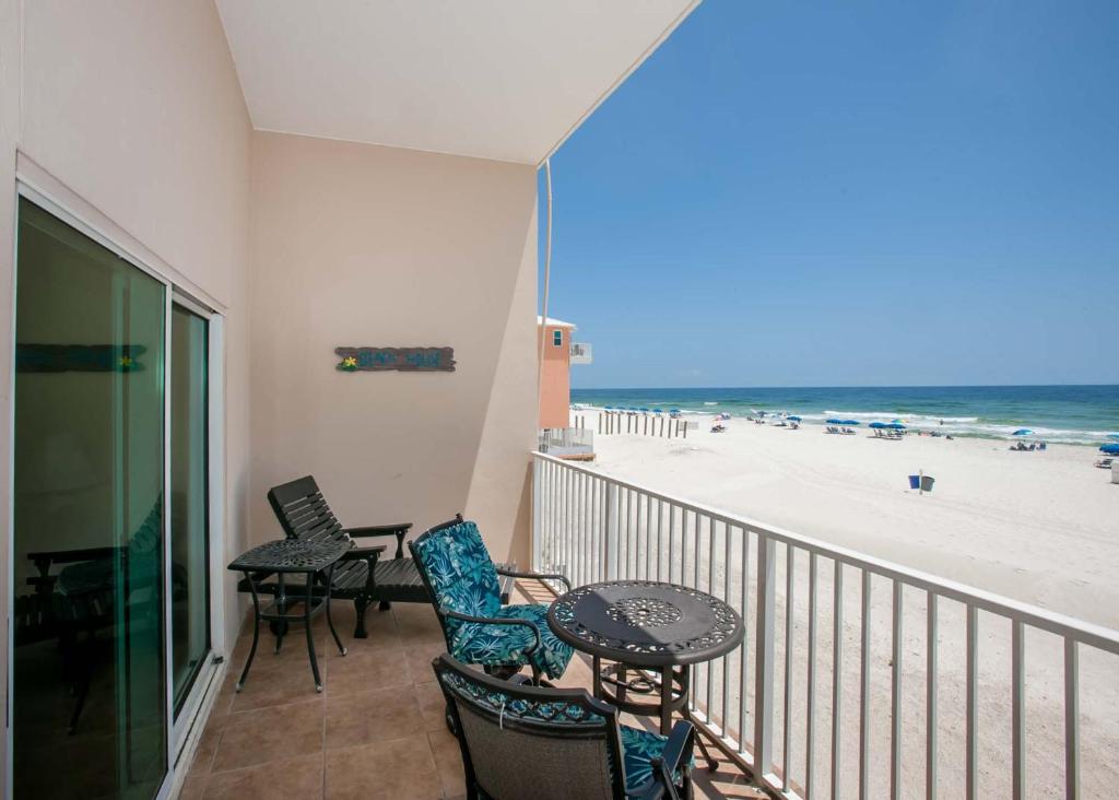 uma varanda com mesa e cadeiras e a praia em Crystal Shores 204 em Gulf Shores