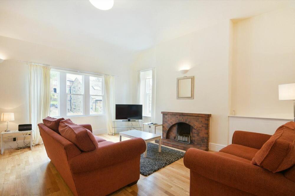a living room with two couches and a fireplace at Decked Out in Alnmouth