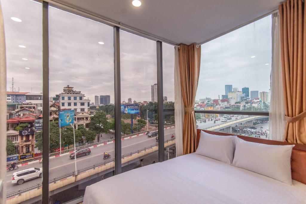 Coco Hotel Cau Giay في هانوي: غرفة نوم بسرير ونافذة كبيرة
