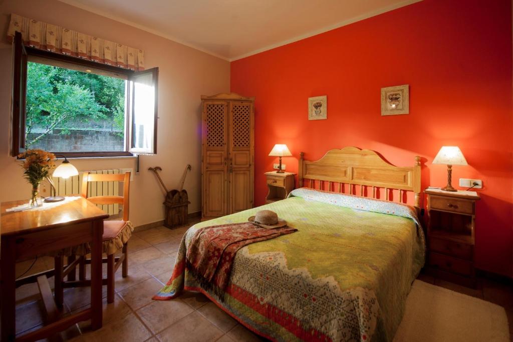 een slaapkamer met een bed, een bureau en een raam bij Santu Colás in Corao