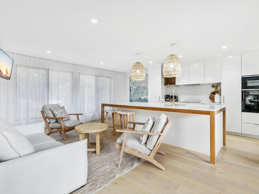 Una cocina y una sala de estar con mesa y sillas. en 11 Attunga Heights Noosa Heads, en Noosa Heads