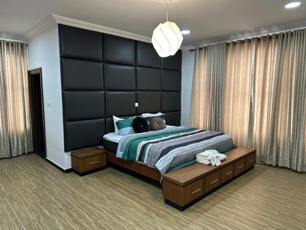 una camera da letto con un grande letto con una grande testiera nera di Nigus House Oniru a Lagos