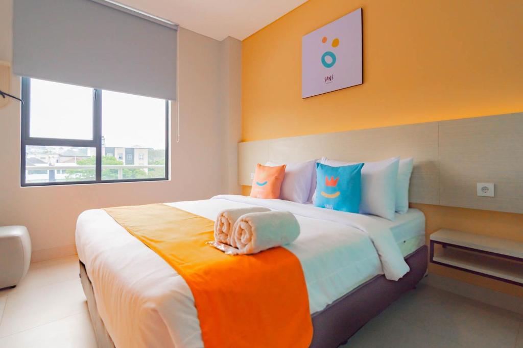 Postel nebo postele na pokoji v ubytování Sans Hotel Alexander Bandung