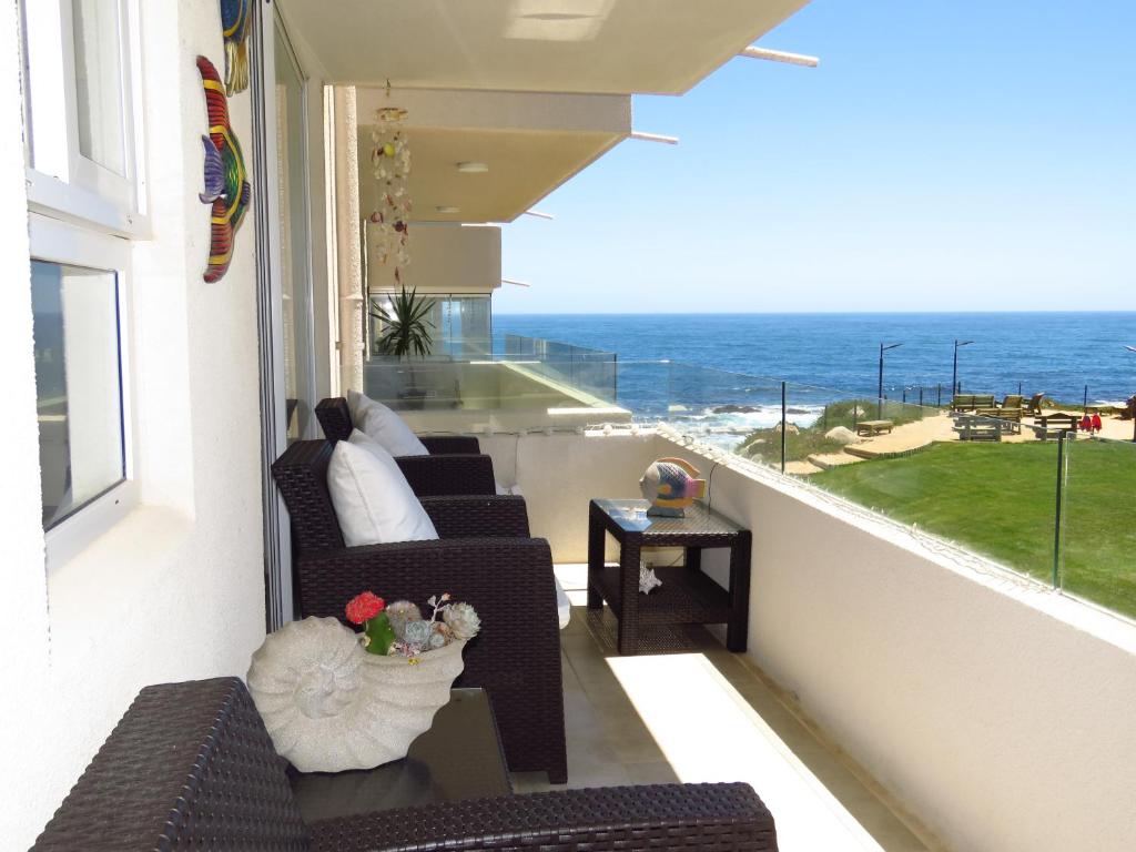 a balcony with chairs and a view of the ocean at Departamento AltoMar El Tabo Isla Negra in El Tabo