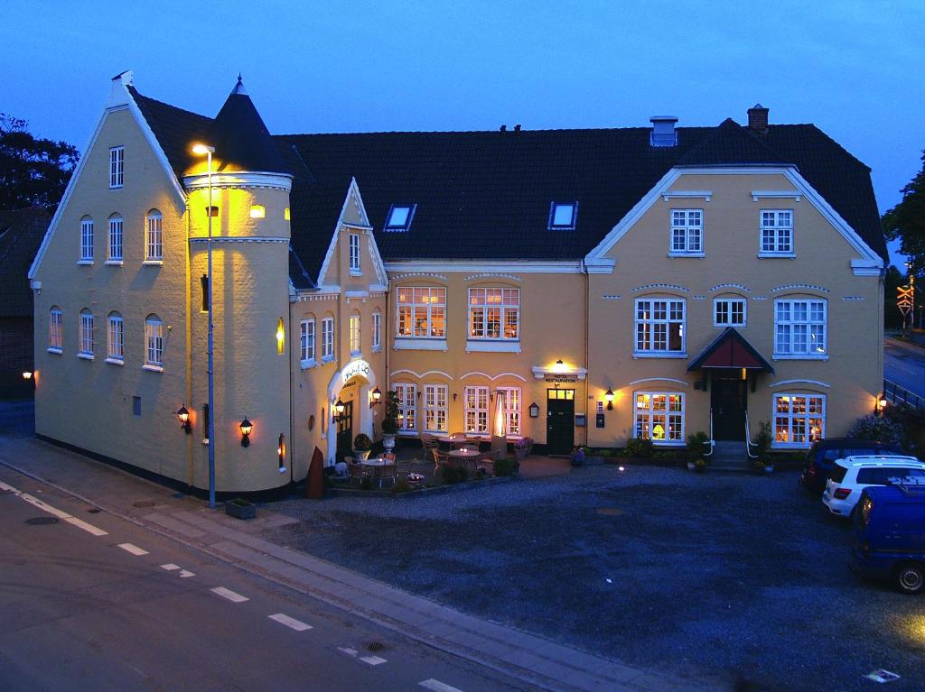 uma casa grande com um carro estacionado em frente em Hotel Højslev Kro em Højslev