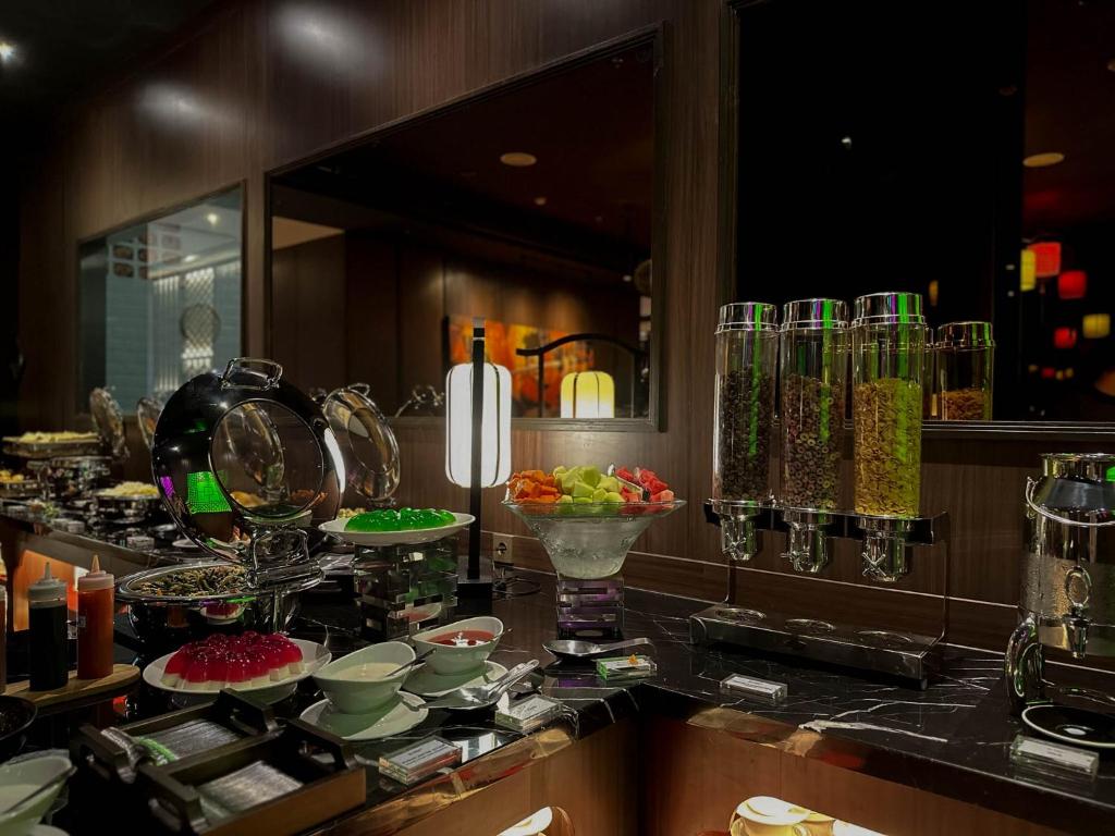 a kitchen with a counter with bowls and plates of food at Ashley Tang Menteng Jakarta in Jakarta