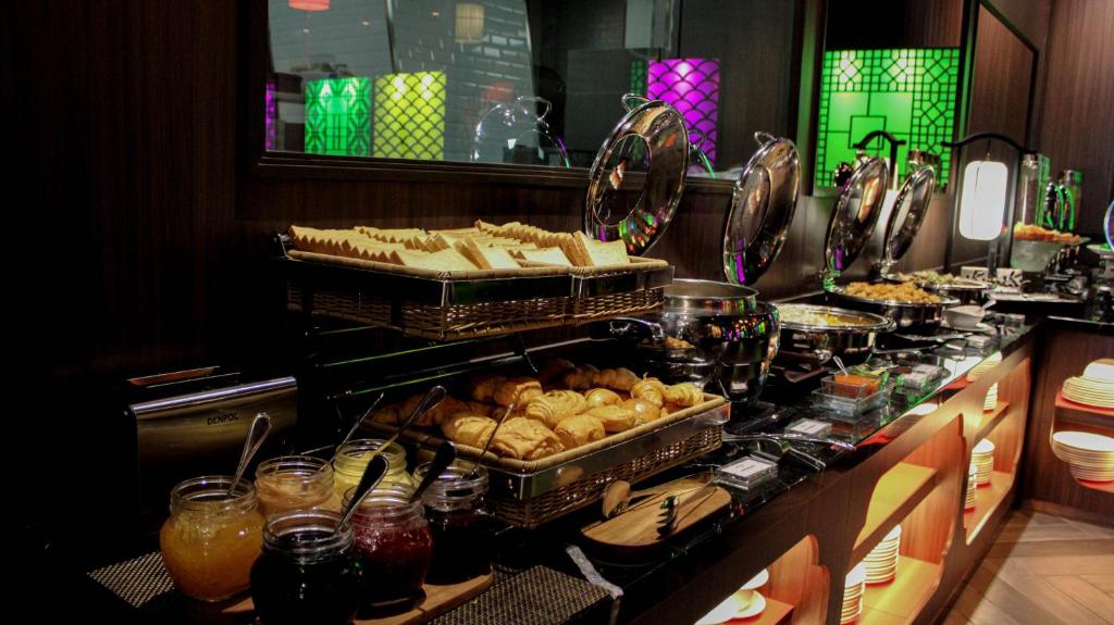 a buffet line with trays of food and pastries at Ashley Tang Menteng Jakarta in Jakarta