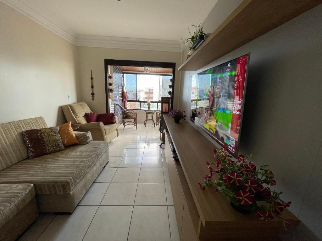 sala de estar con sofá y TV de pantalla plana en Apartamento Maravilhoso, en Capão da Canoa