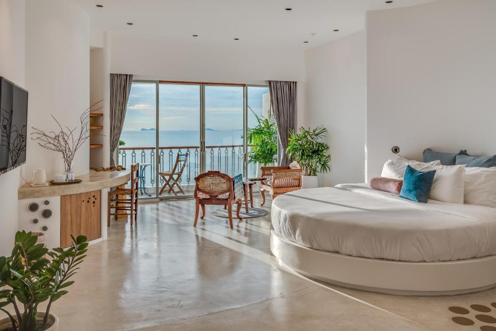 um quarto com uma cama grande e uma varanda em Ampersand Resort em Bophut