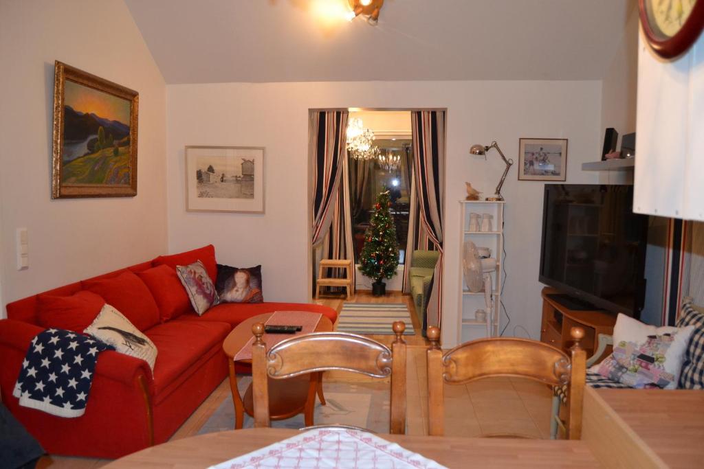 sala de estar con sofá rojo y árbol de Navidad en Villa Linnunlaulu en Löparö