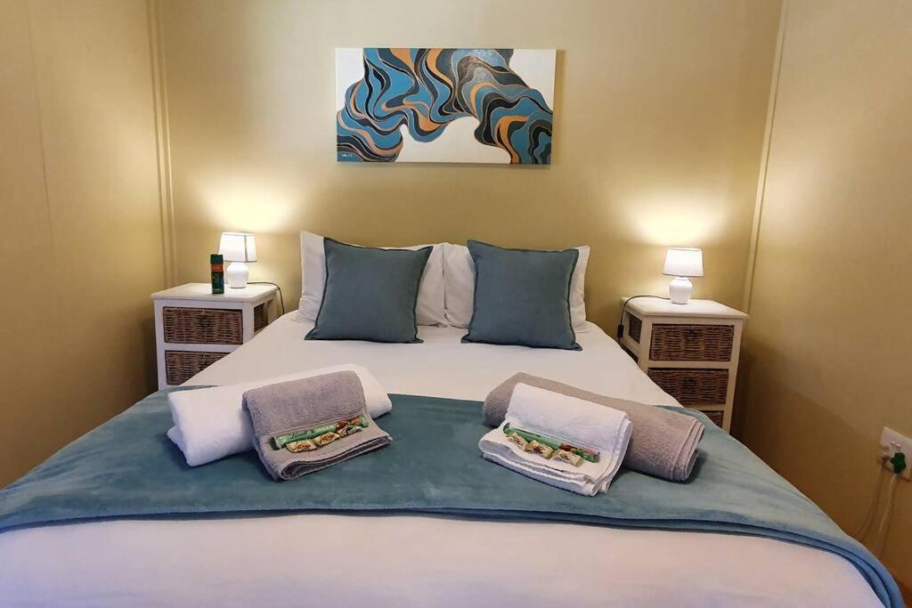 1 dormitorio con 1 cama con 2 almohadas en Jakaranda Cabin - Self Catering Apartment, en Secunda