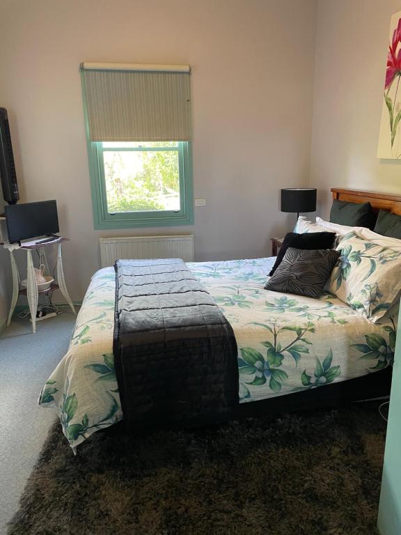 a bedroom with a bed and a window at Butlers Guesthouse in Birregurra