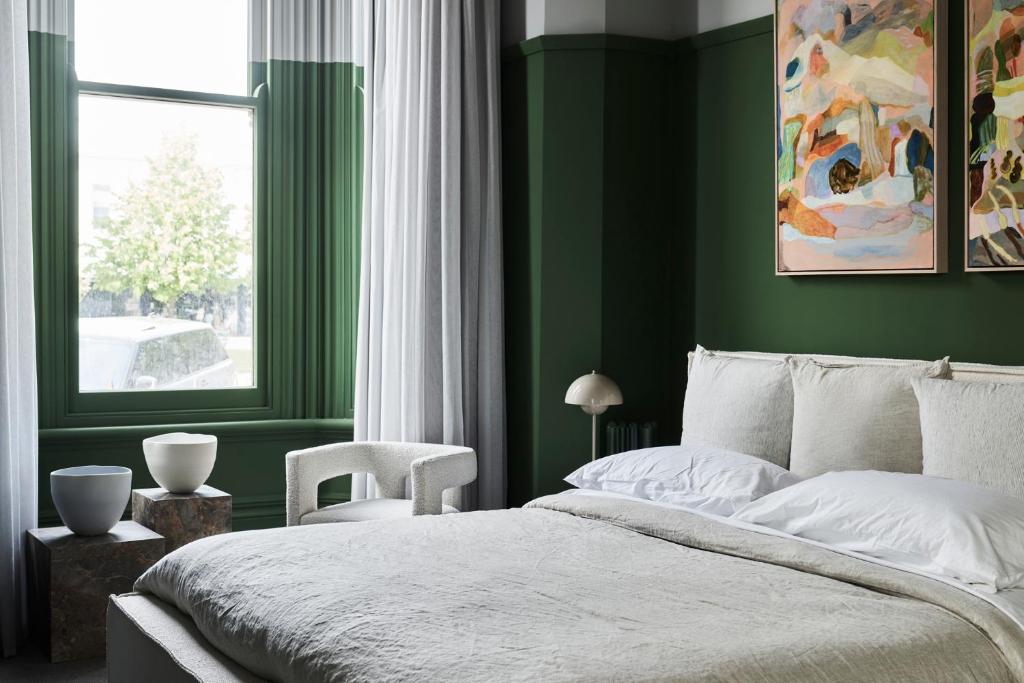um quarto verde com uma cama e uma janela em Hotel Vera Ballarat em Ballarat