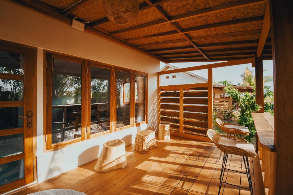Happy home في Huu: شاشة في الشرفة مع أرضيات خشبية ونوافذ