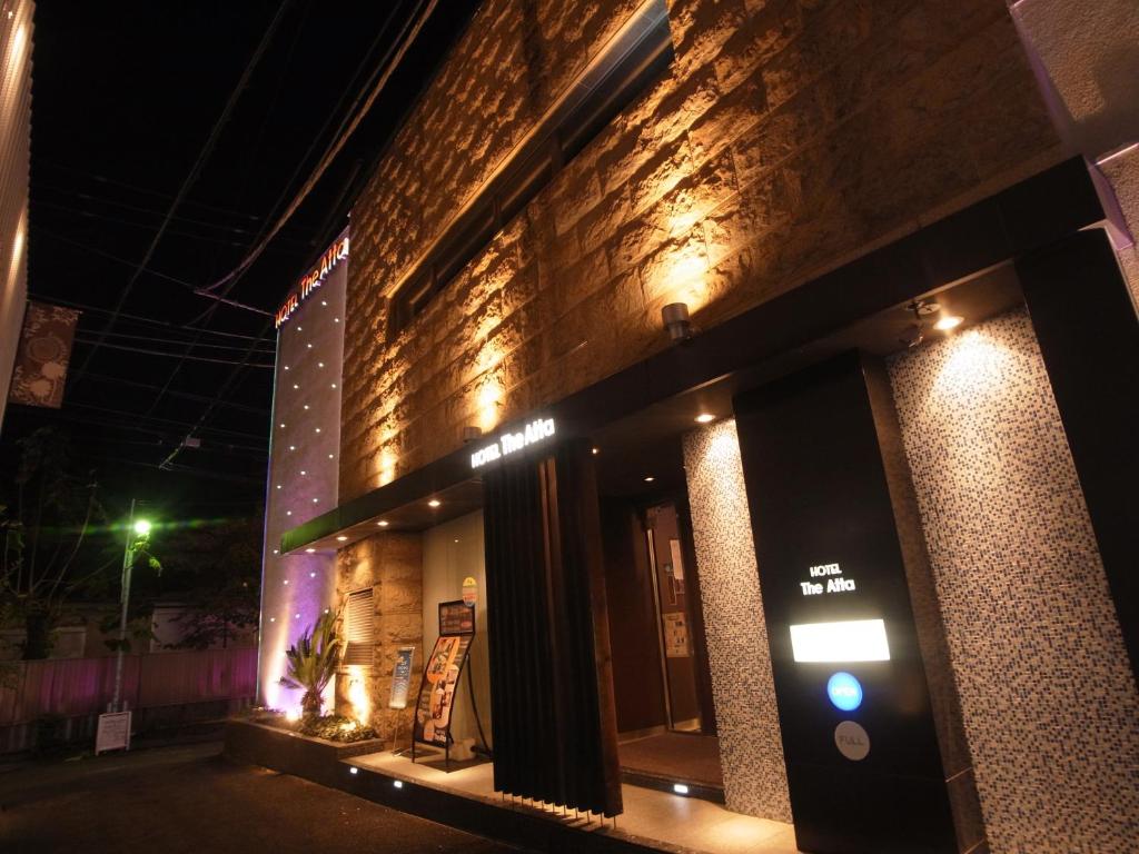 a brick building with a sign on it at night at Hotel THE ATTA Adult Only in Tokyo