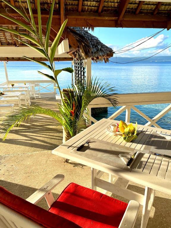 a table and chairs on a beach with the ocean at Coco Beach Resort in Port Vila