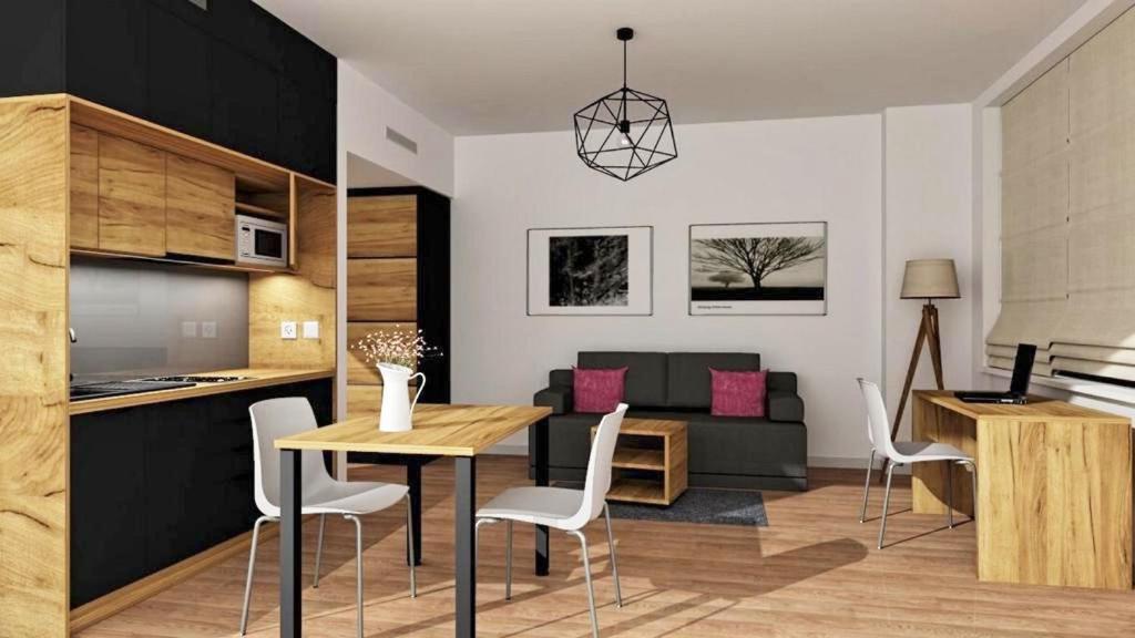uma cozinha e uma sala de estar com mesa e cadeiras em Apartimento Hydral Magari em Breslávia