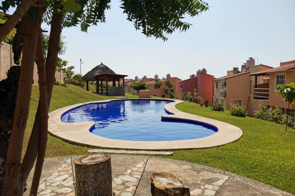 a swimming pool in a yard with a gazebo at Casa Loma Flamingos Ixtapa in Ixtapa