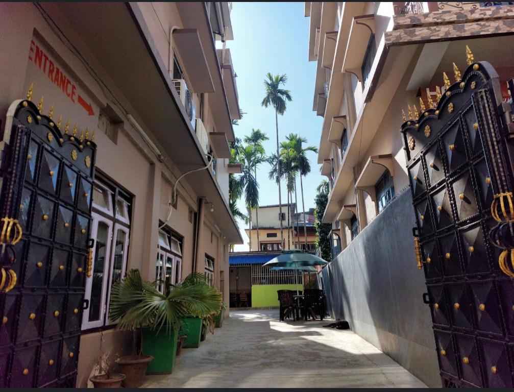 an alley with a gate in a building with palm trees at Hotel Quality in Kakarvitta