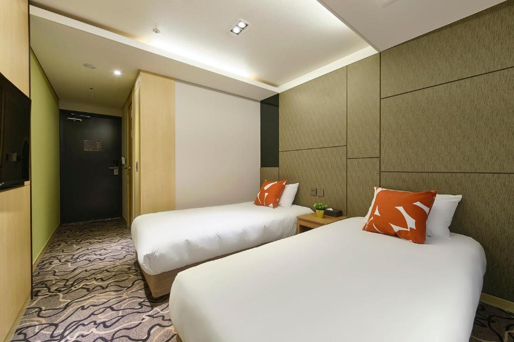 Ένα ή περισσότερα κρεβάτια σε δωμάτιο στο Jeju Grace Hotel