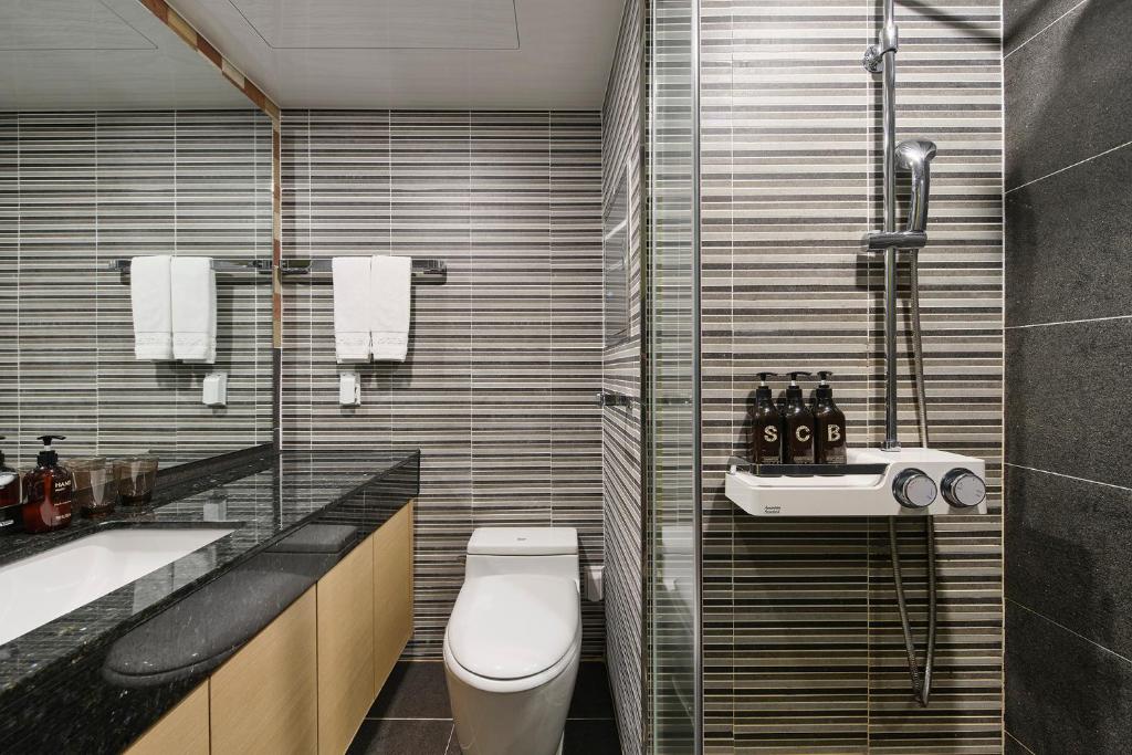a bathroom with a toilet and a sink and a shower at JEJU Western Grace Hotel in Seogwipo