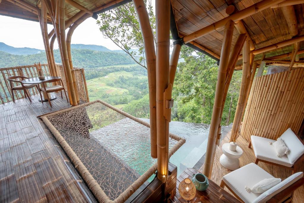 Cette chambre offre une vue sur une cabane dans les arbres. dans l'établissement Cliffside Bamboo Treehouse with Pool and View, à Bungbungan