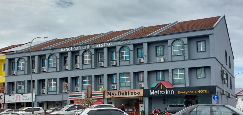 a large building with cars parked in a parking lot at Metroinn Hotel in Arau